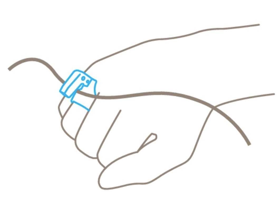 Jedna ręka trzyma przewód. Urządzenie jest przymocowane do przewodu i ręki, prawdopodobnie w celu pomiaru lub przytrzymania przewodu.