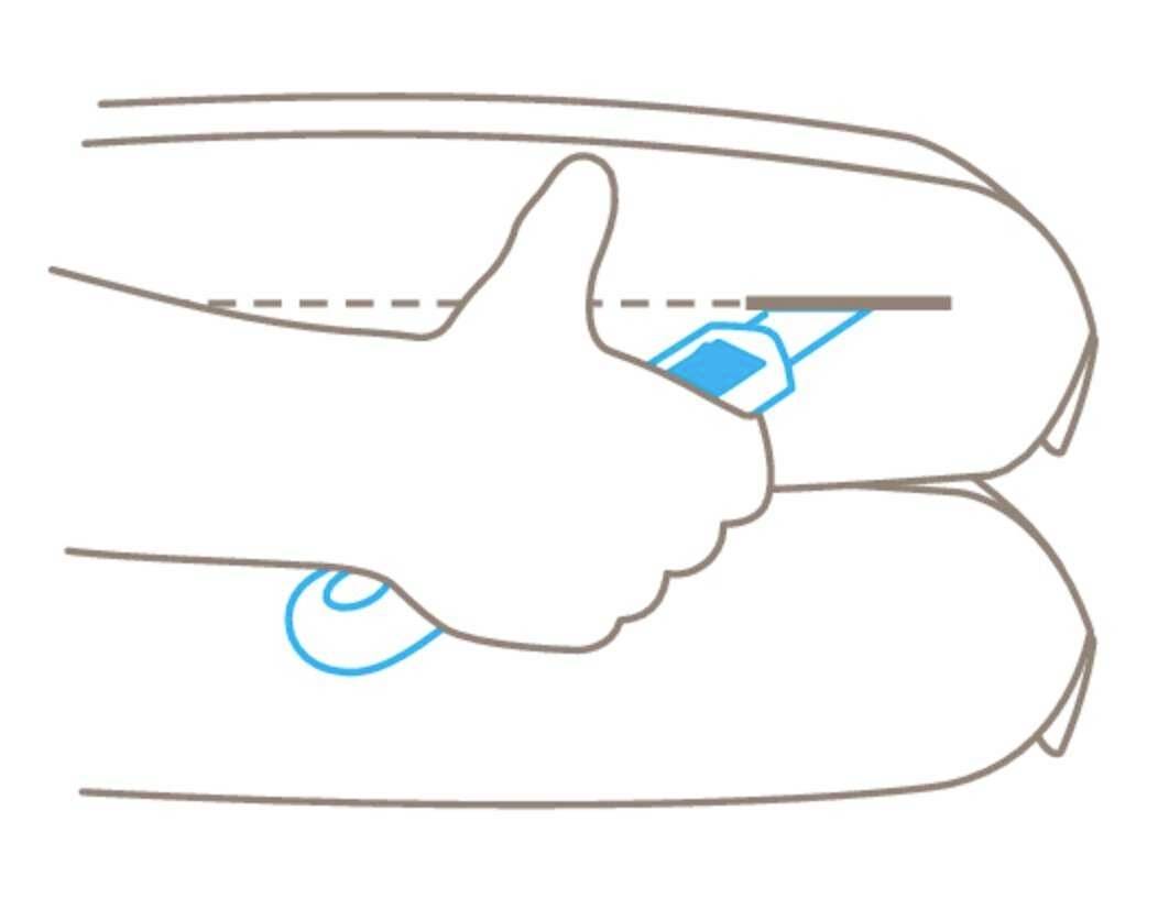 Dłoń trzyma kartę bezpieczeństwa przed pasem bezpieczeństwa, demonstrując zastosowanie zabezpieczenia.