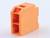 Pomarańczowy blok plastikowy z prostokątnymi wycięciami i ściętą górną krawędzią, prawdopodobnie element składowy lub część jakiegoś urządzenia.