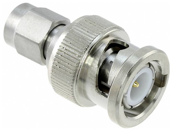 Metalowy złącze BNC charakteryzujące się cylindrycznym kształtem z nacinkami ułatwiającymi chwyt i centralnym stykiem przeznaczonym do połączeń kabli współosiowych.