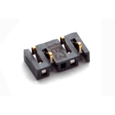 Mały czarny wtyk z tworzywa sztucznego z trzema złotymi stykami, leżący na białej powierzchni. Element elektroniczny.