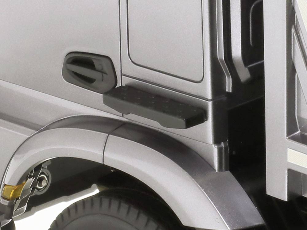 Szczegół szarego modelu pojazdu, ukazujący lewą tylną strefę koła oraz fragment nadwozia.