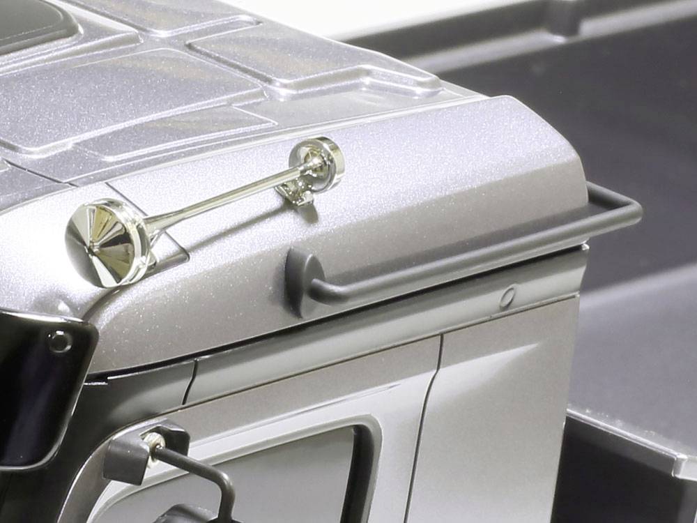 Srebrny model samochodu z detalami, takimi jak lusterka boczne i klamki drzwi, starannie zaprojektowanymi, aby wyglądać realistycznie.