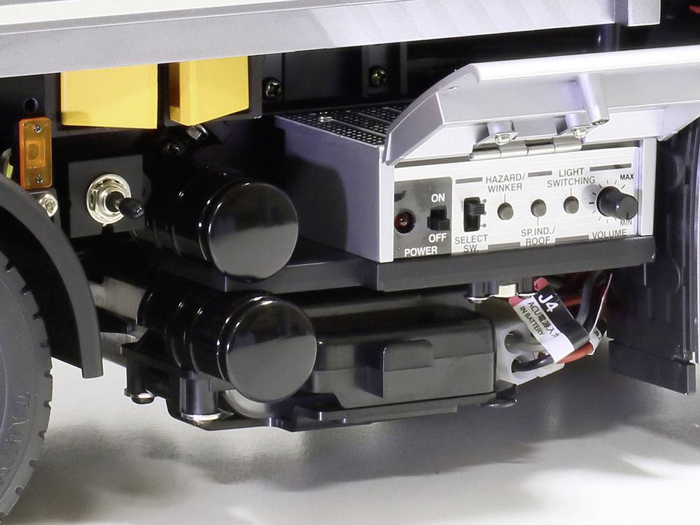 Zbliżenie modelu ciężarówki ukazuje szczegółowe przełączniki i elementy sterujące po stronie pojazdu, w tym pokrętło regulacji głośności.