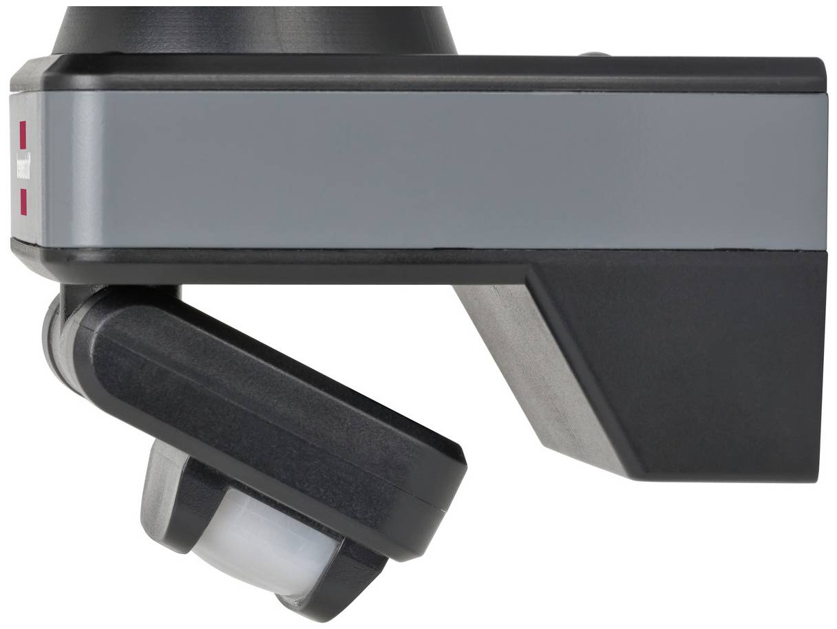 Widok boczny czarnego czujnika ruchu z szarymi akcentami, zamontowanego na uchwycie ściennym.