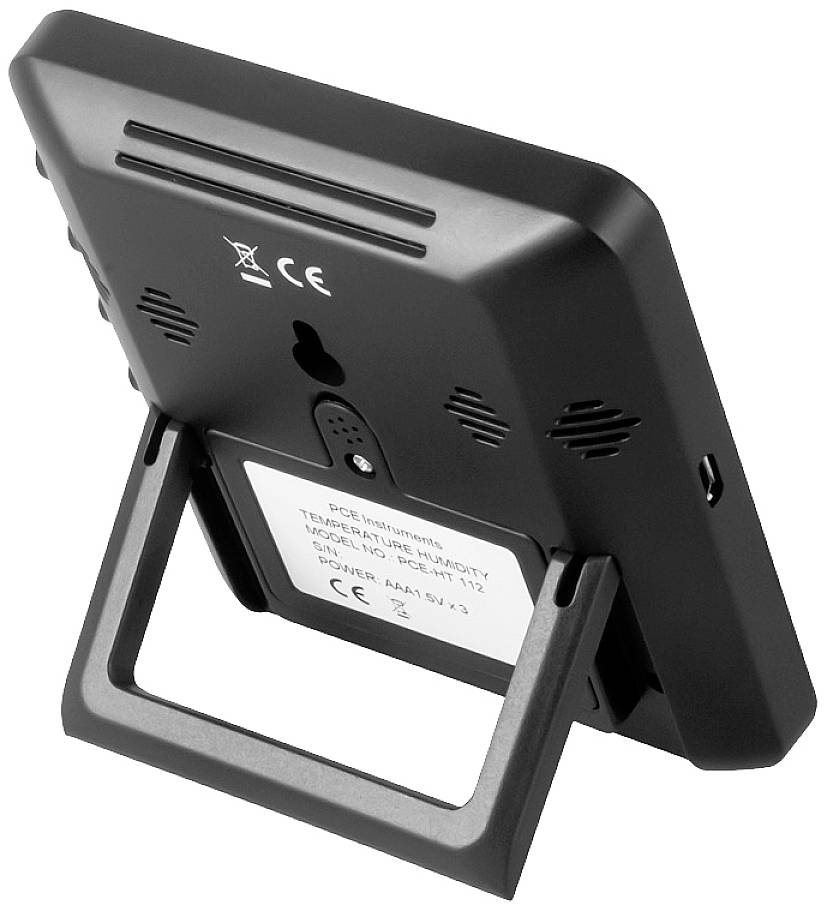 Czarny cyfrowy sprzęt z rozkładaną podstawką, klapką komory baterii i otworami wentylacyjnymi z tyłu. Oznaczenie CE widoczne.