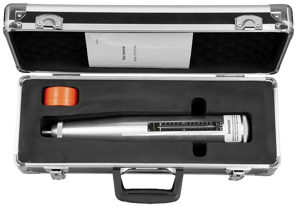 Srebrno-szary młotek do badań w czarnej walizce z czerwonym elementem. Certyfikowane urządzenie pomiarowe do oceny budowlanej.