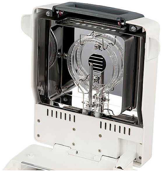 Elektroniczne urządzenie z otwartą obudową, ukazujące komponenty wewnętrzne, takie jak lampa i szczeliny wentylacyjne. Wydaje się być przeznaczone do celów technicznych.