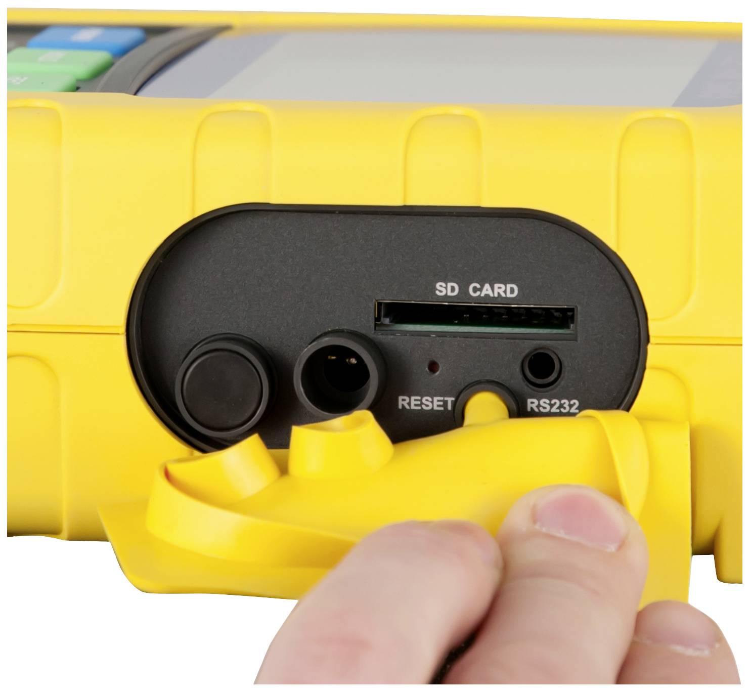 Żółte urządzenie z odkrytym dostępem do gniazd karty SD i interfejsu RS232. Jedna ręka przytrzymuje pokrywę.
