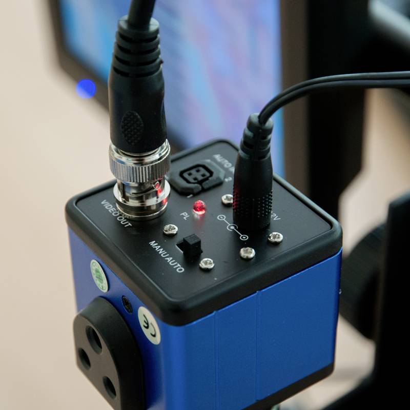 Zbliżenie niebieskiego urządzenia elektronicznego z wieloma złączami i przewodami. Na tle wyświetlacza widoczny jest wzór.