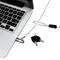 Laptop z zamkiem zabezpieczającym i kablem, obok niego dwa klucze. Zamek jest przymocowany do laptopa, aby zapobiec kradzieży.