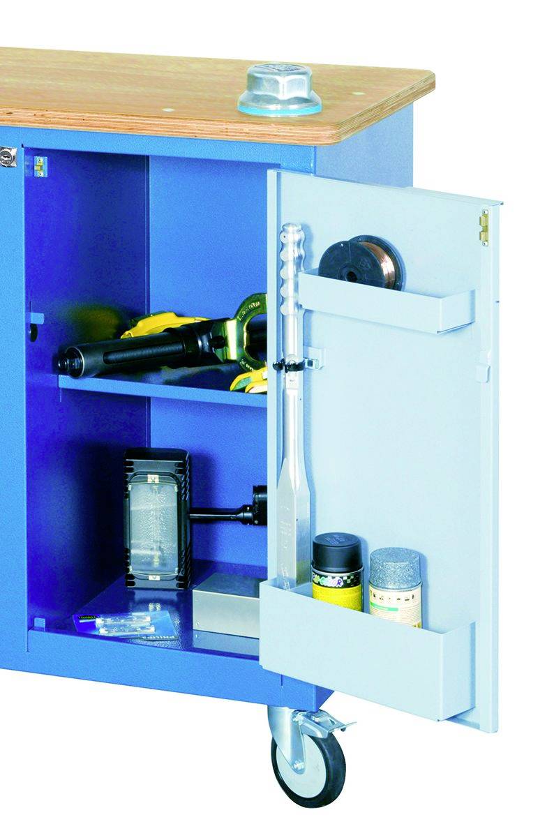 Niebieski wózek warsztatowy z drewnianym blatem, otwartymi drzwiami i widocznymi narzędziami oraz materiałami, takimi jak spray'e, młotek i elektronarzędzia.