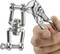 Dłoń trzyma szczypce, które zaciskają obrotowy szekiel. Szekiel jest wykonany z lśniącego metalu i prezentuje mechaniczne połączenia.