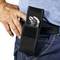 Osoba nosi szczypce w czarnej torbie na pasie, która jest przymocowana do paska od jeansów. Ręka spoczywa na biodrze.