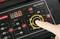 Dłoń obsługuje ładowarkę z cyfrowym wyświetlaczem i różnymi ustawieniami rodzajów baterii oraz natężenia prądu ładowania.