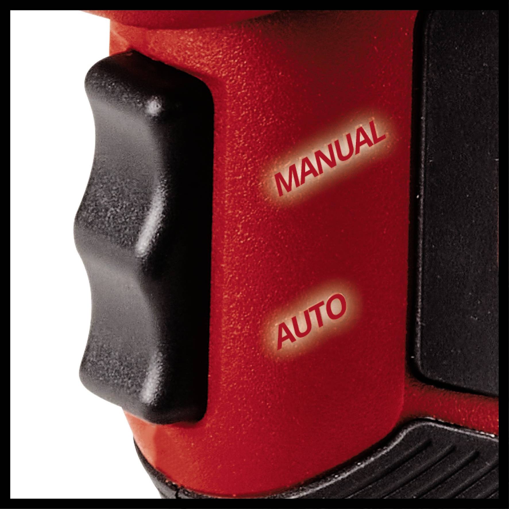 Zbliżenie przełącznika na czerwonym urządzeniu z napisami 'MANUAL' i 'AUTO', wskazującymi na różne tryby pracy.