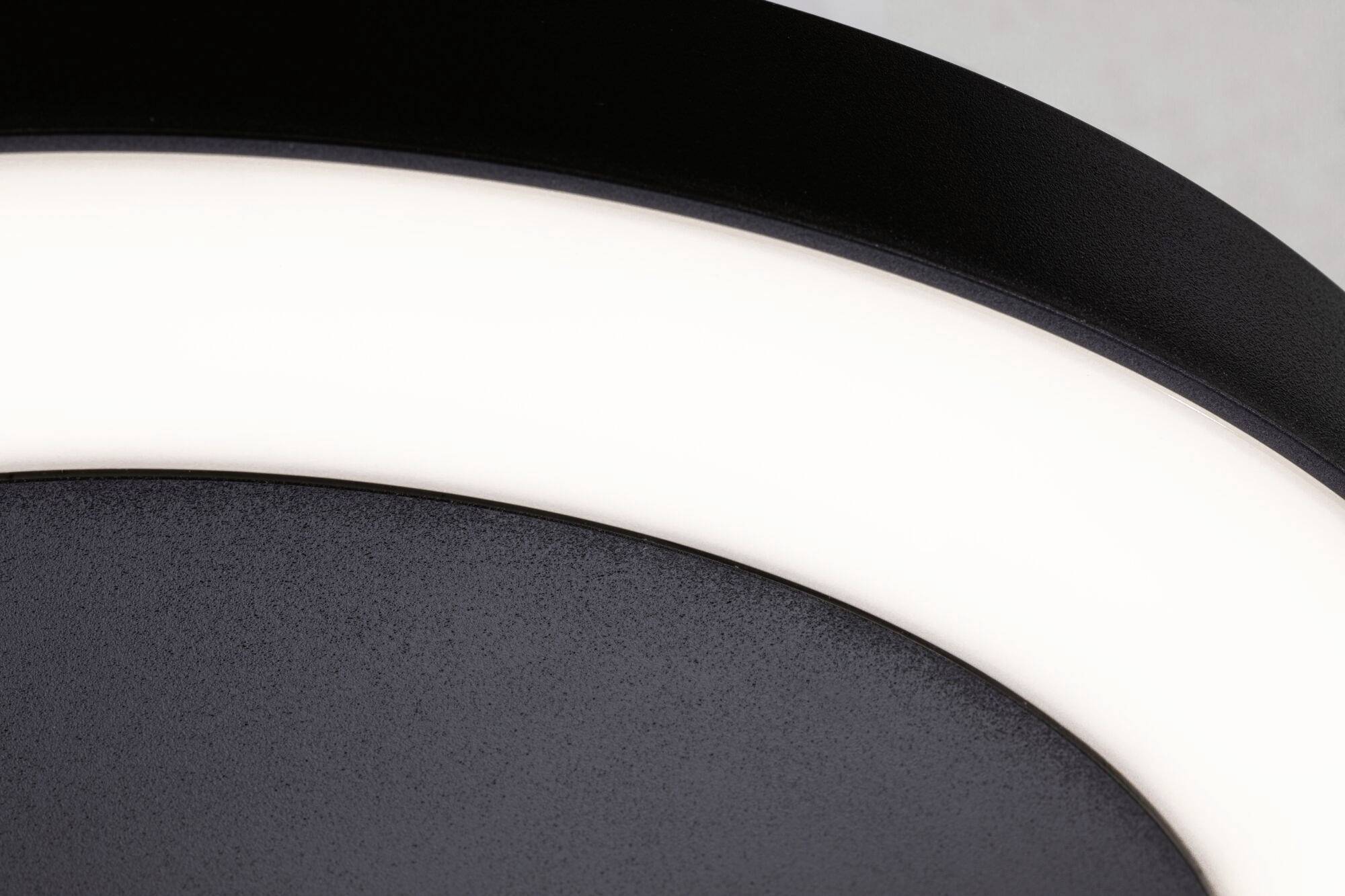 Zbliżenie świecącego pierścieniowego światła LED z gładką, czarną powierzchnią w tle.