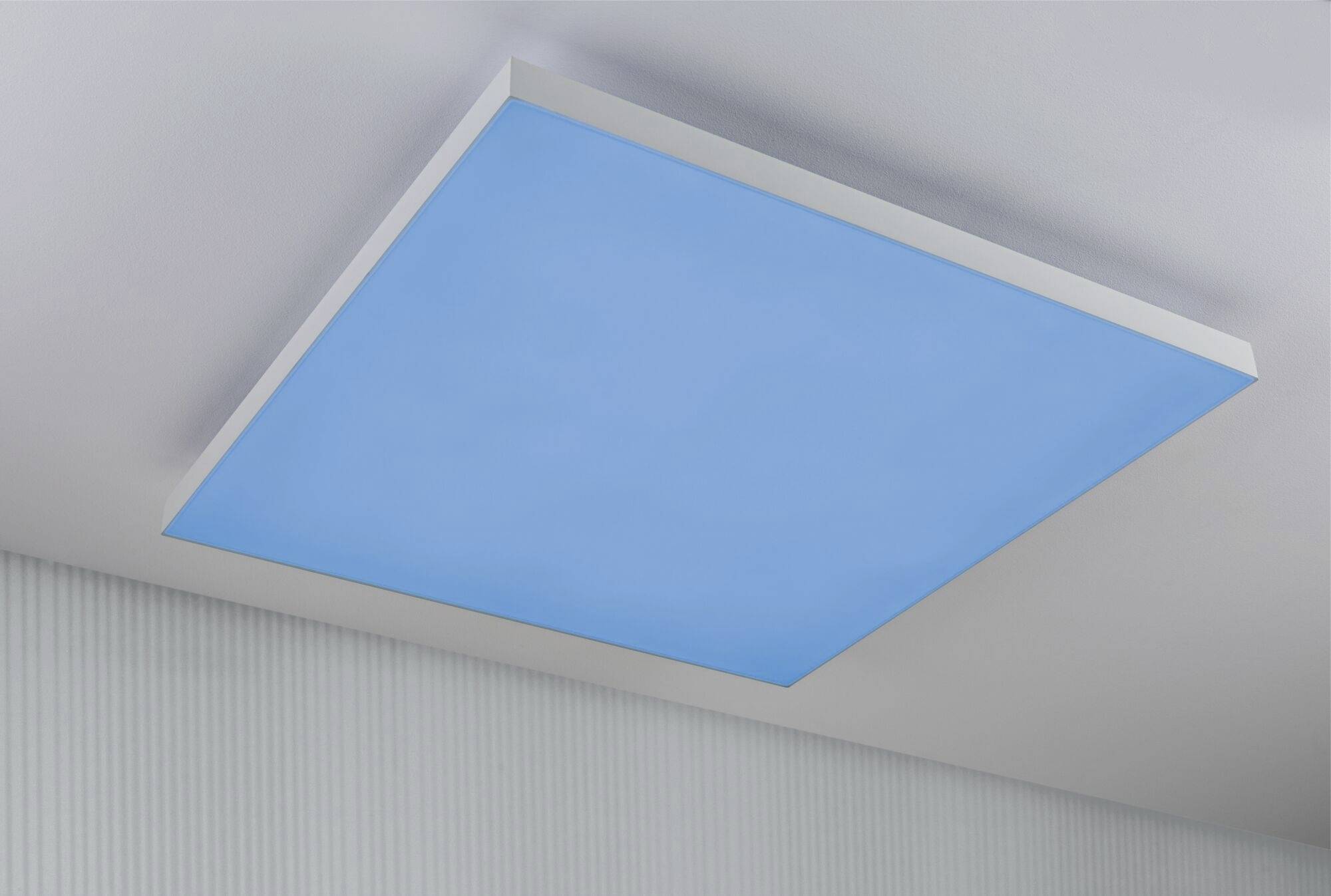 Lampa sufitowa z kwadratowym, niebiesko świecącym panelem na jasnoszarej suficie. Minimalistyczny design, nowoczesne oświetlenie.