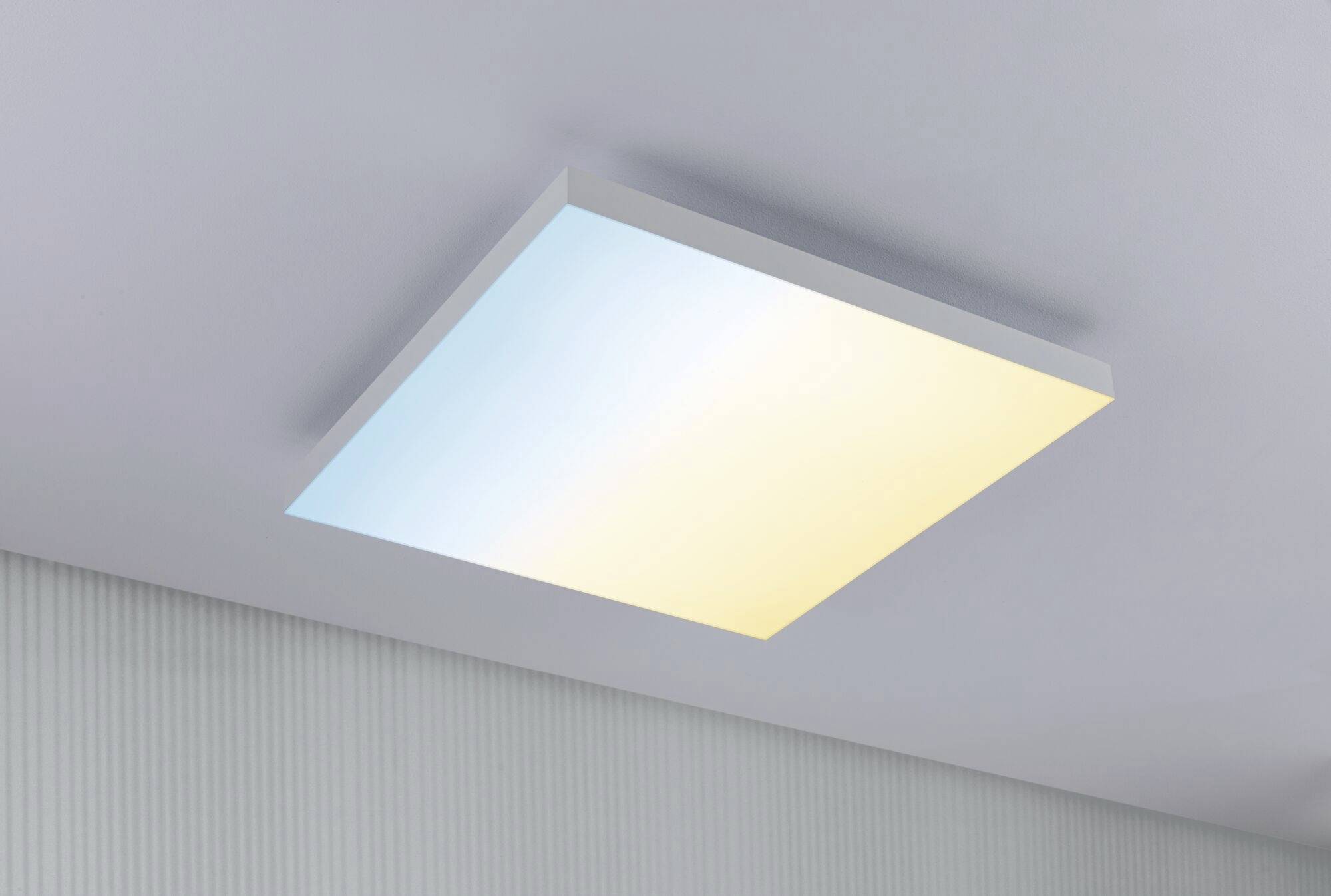 Prostokątna lampa sufitowa z delikatnym przejściem z błękitu w żółć, zamontowana na białym suficie, o nowoczesnym, minimalistycznym designie.