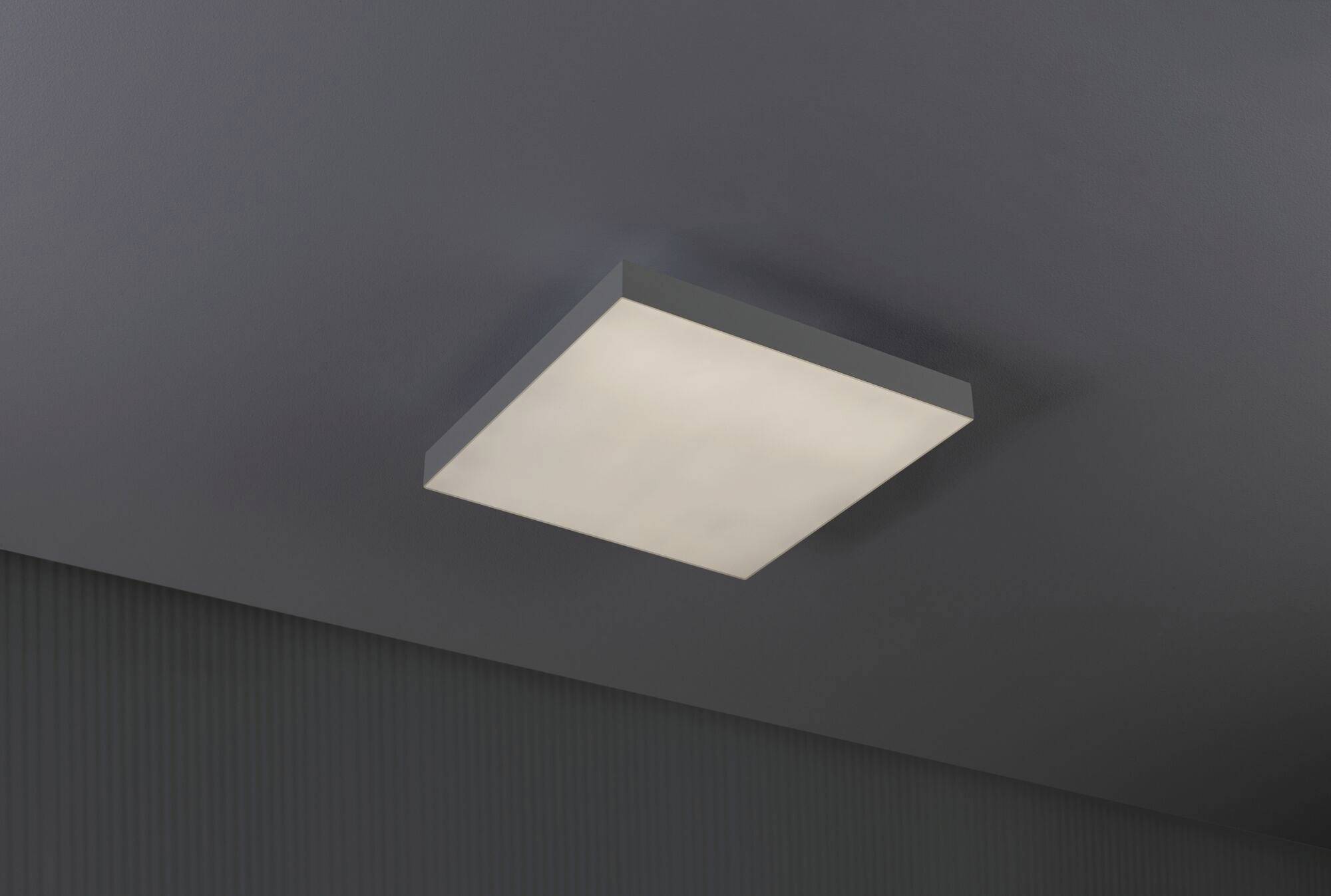 Prostokątna lampa sufitowa o nowoczesnej, minimalistycznej estetyce, zapewniająca ciepłe, równomierne światło w ciemnym pomieszczeniu.