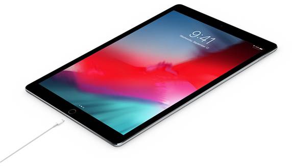 Tablet z kolorowym ekranem, na którym wyświetlana jest godzina '9:41'. U dołu urządzenie jest podłączone do kabla ładującego.