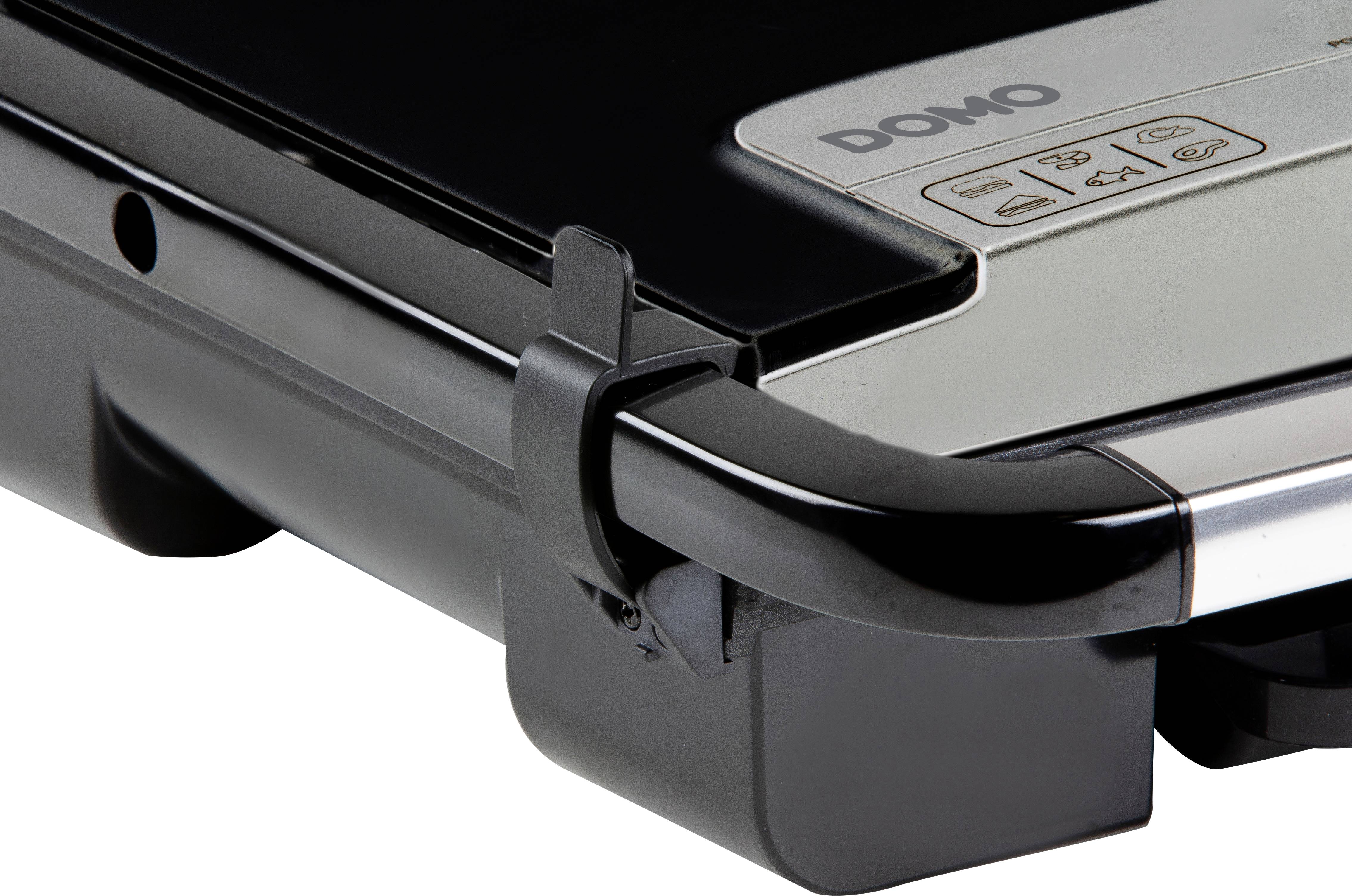 Zbliżenie elektrycznego grilla o czarno-srebrnym designie, z widocznym zamknięciem bocznym i pokrętłami sterującymi na górze.