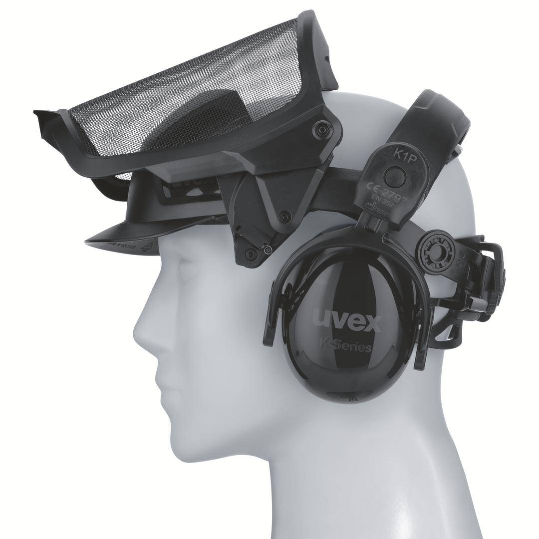 Manekin wystawowy nosi maskę z siatki oraz parę nauszników ochronnych.