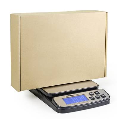 Cyfrowa waga wskazuje 7,9 kg, podczas gdy waży duży, zamknięty, brązowy karton.