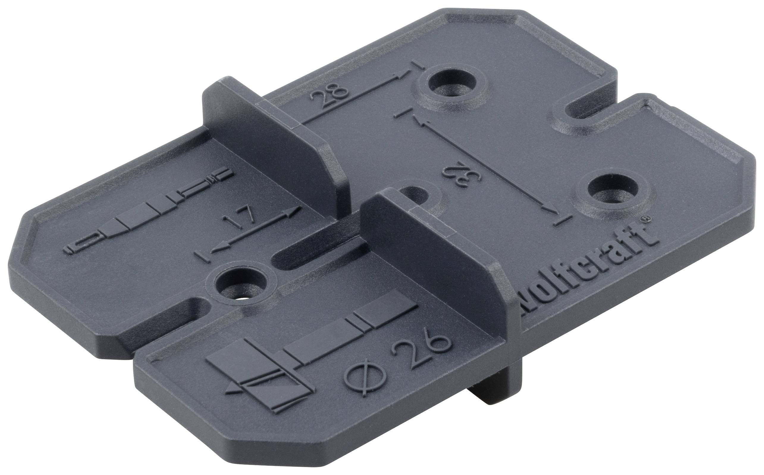 Szary element plastikowy z podziałką pomiarową i otworami, opisany cyframi i logo marki, służy jako szablon lub narzędzie.