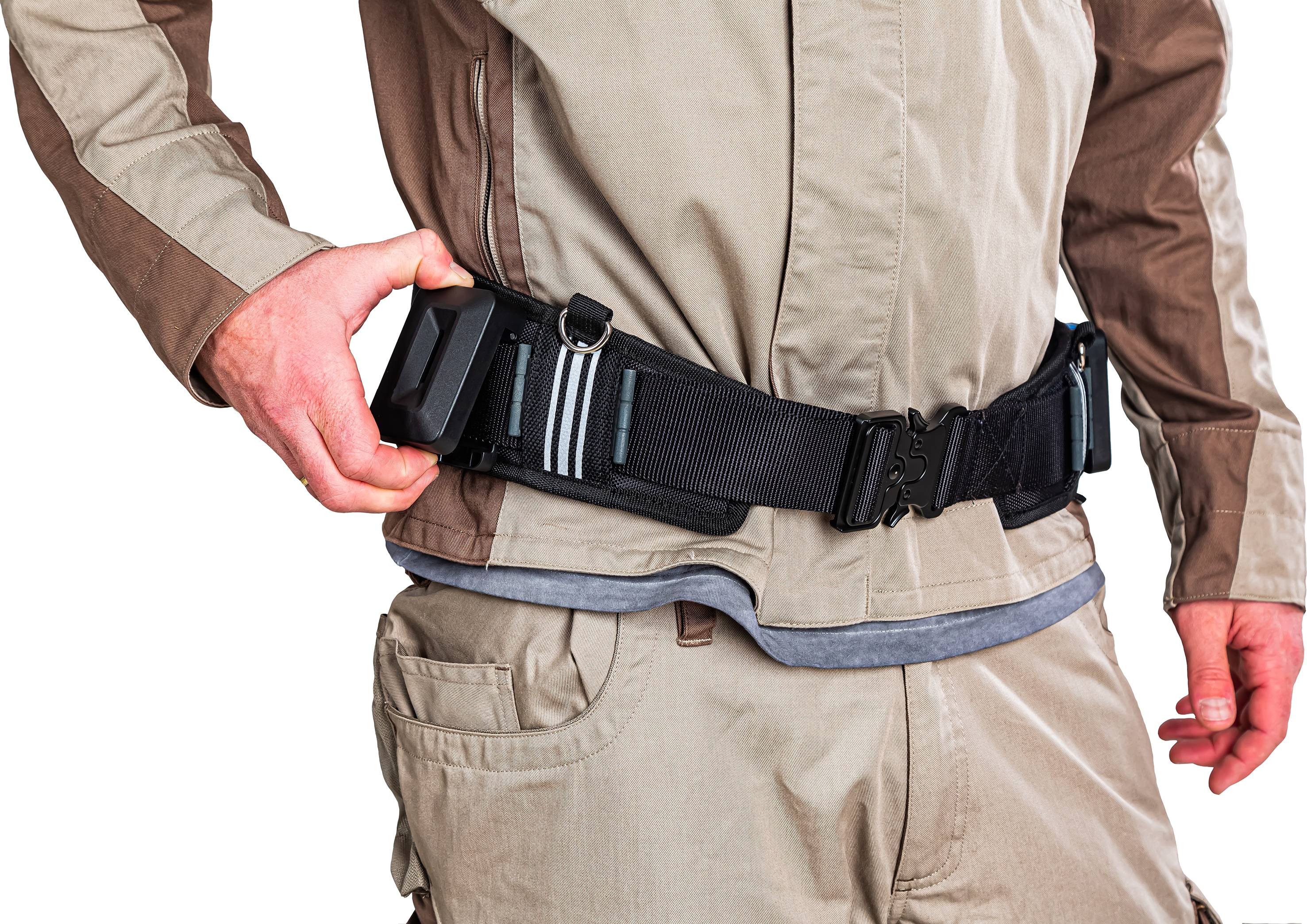 Osoba w odzieży roboczej nosi pas narzędziowy z wieloma kieszeniami. Ręka reguluje pas.