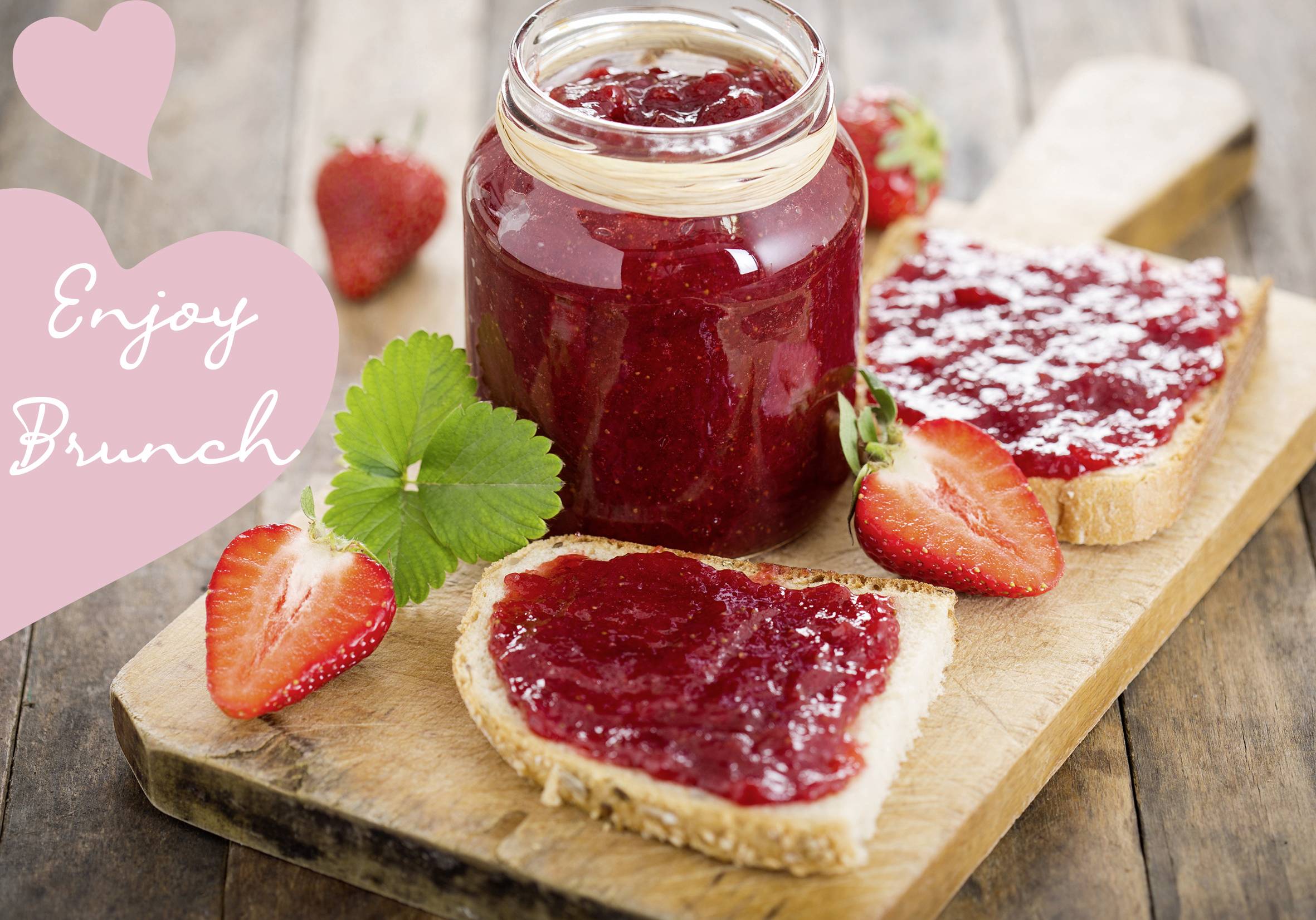 Rustykalna deska drewniana z otwartym słoikiem dżemu truskawkowego, dwoma posmarowanymi kromkami chleba i świeżymi truskawkami. Tekst: 'Enjoy Brunch'.