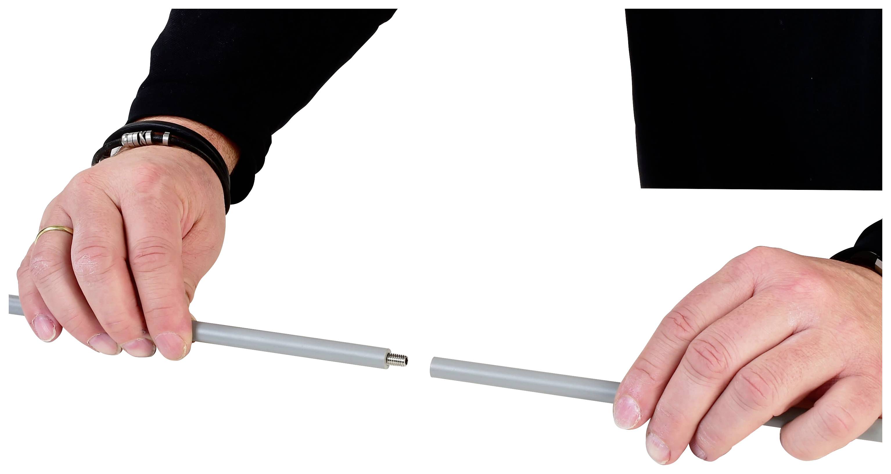 Dwie ręce trzymają każda jeden koniec szarej metalowej pręgi, która jest przerwana w środku.