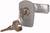 Klucz tkwi w zamku cylindrycznym, obok niego leży kolejny klucz. Zamek znajduje się w szarej obudowie.