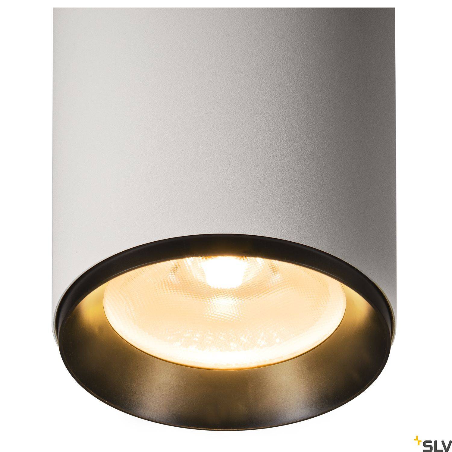 Lampa sufitowa o białym cylindrycznym kształcie z ciepło świecącą żarówką, umieszczona w nowoczesnym, minimalistycznym wnętrzu.