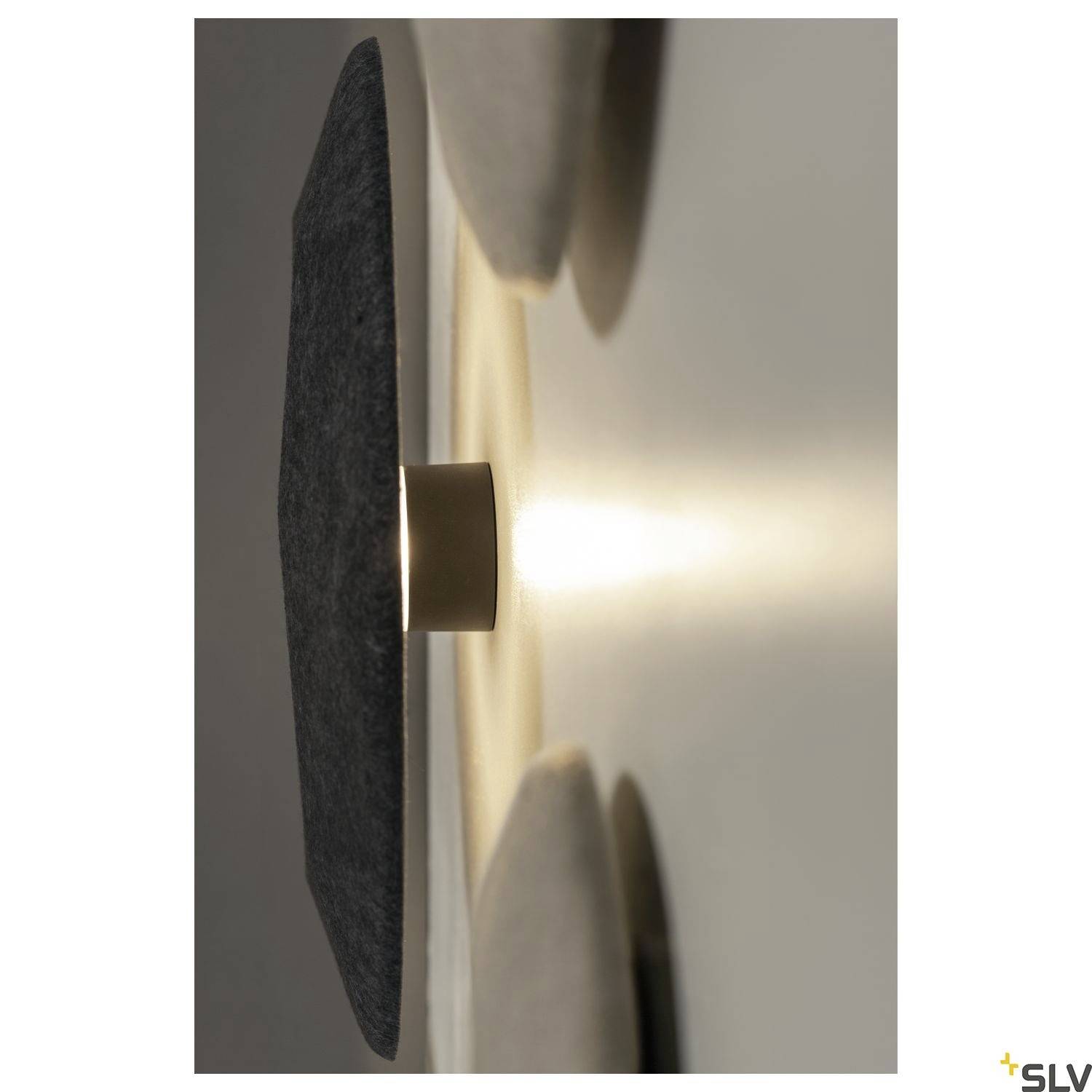 Nowoczesny kinkiet o okrągłym, płaskim kształcie z ciepłym światłem, zamontowany na białej ścianie. Idealny do tworzenia nastrojowego oświetlenia.