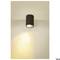Lampa sufitowa z cylindryczną czarną oprawą i ciepłym blaskiem na ścianie. Minimalistyczny design do wnętrz.
