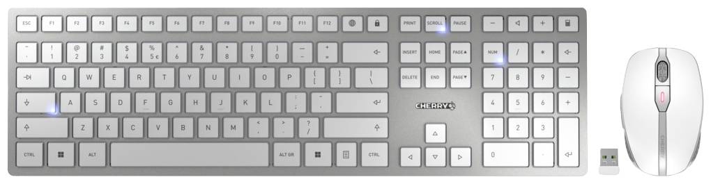 Bezprzewodowa srebrna klawiatura i mysz z odbiornikiem USB, widoczne podświetlane klawisze, na białym tle.