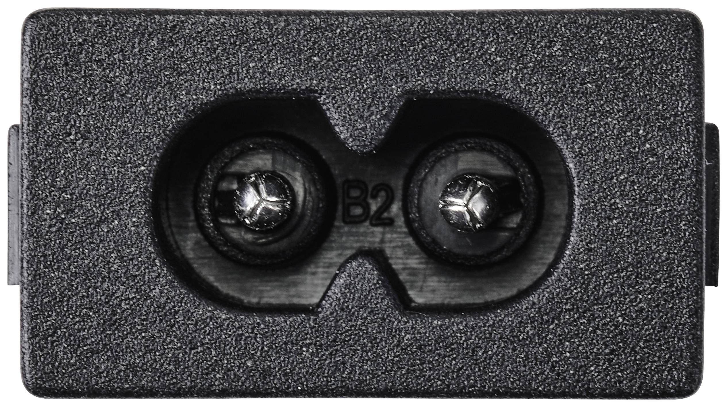 Zbliżenie prostokątnego złącza z dwoma okrągłymi otworami i oznaczeniem 'B2' wewnątrz.