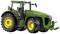 Zielony traktor z żółtymi kołami, widziany z boku. Logo firmy na masce silnika. Przeznaczony do użytku rolniczego.