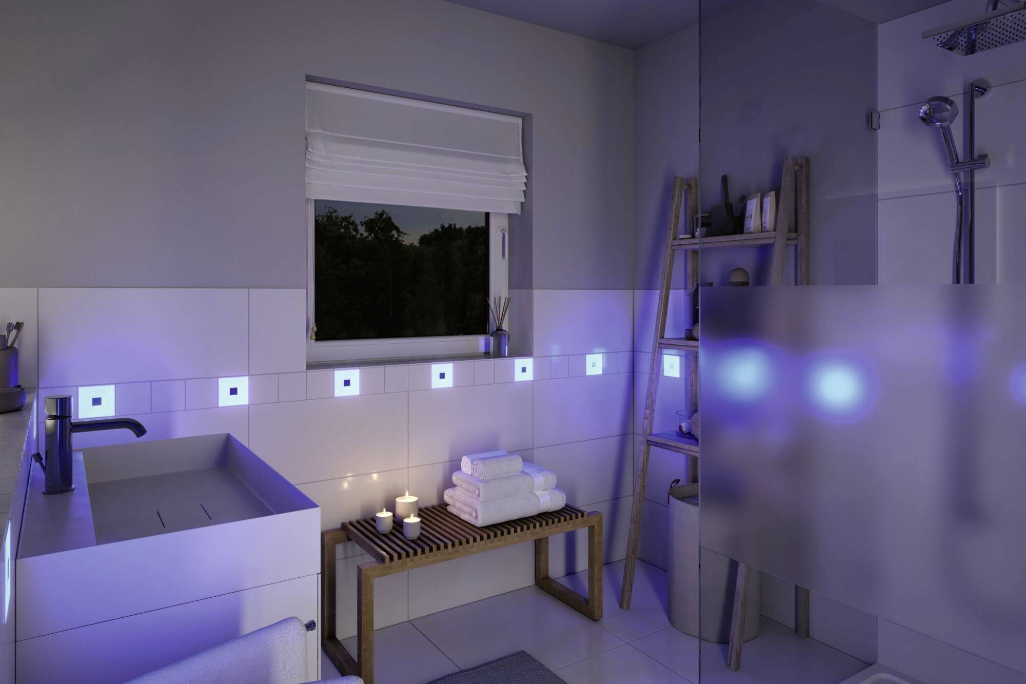 Nowoczesna łazienka w nocnej scenerii z niebieskim oświetleniem LED. Umywalka, półka na ręczniki i świece tworzą relaksującą atmosferę.