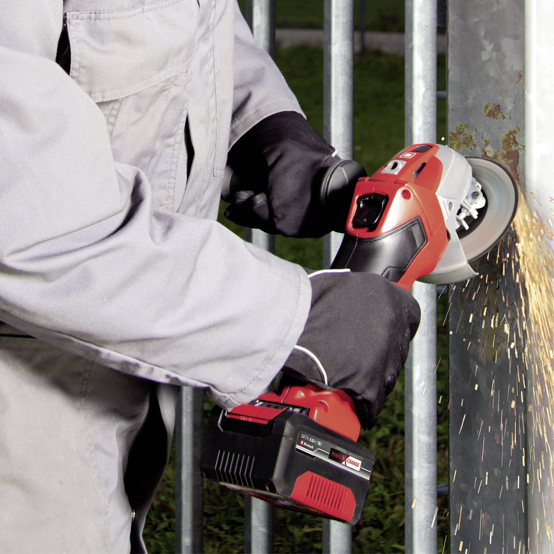 Osoba szlifuje metal czerwoną szlifierką kątową, a z boku tryskają iskry. Nosi rękawice i odzież ochronną.