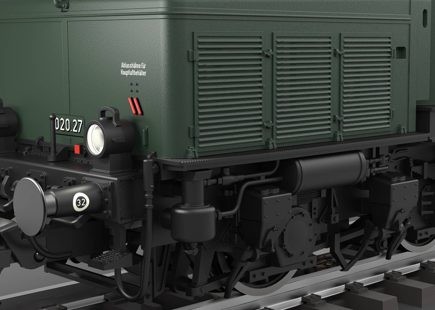 Lokomotywa w ujęciu z bliska, prezentująca szczegóły przedniej części, w tym reflektory i napisy. Ciemnozielona bryła na torach.