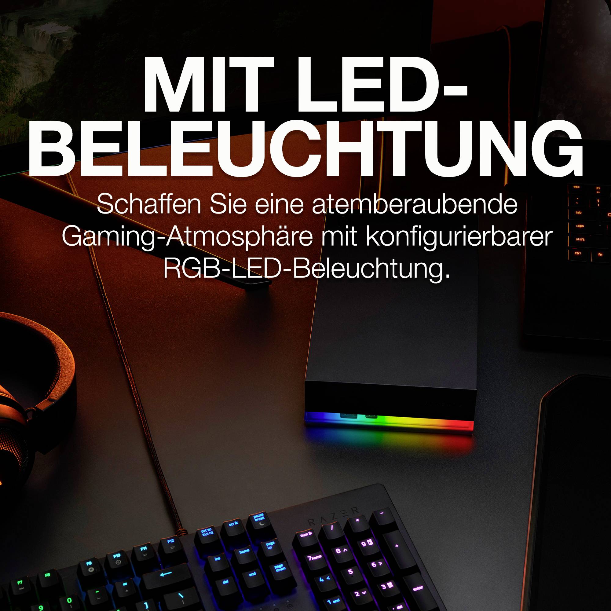 Słuchawki i klawiatura na stole z podświetleniem RGB LED. Tekst na górze: 'Z podświetleniem LED'. Tworzy atmosferę dla graczy.