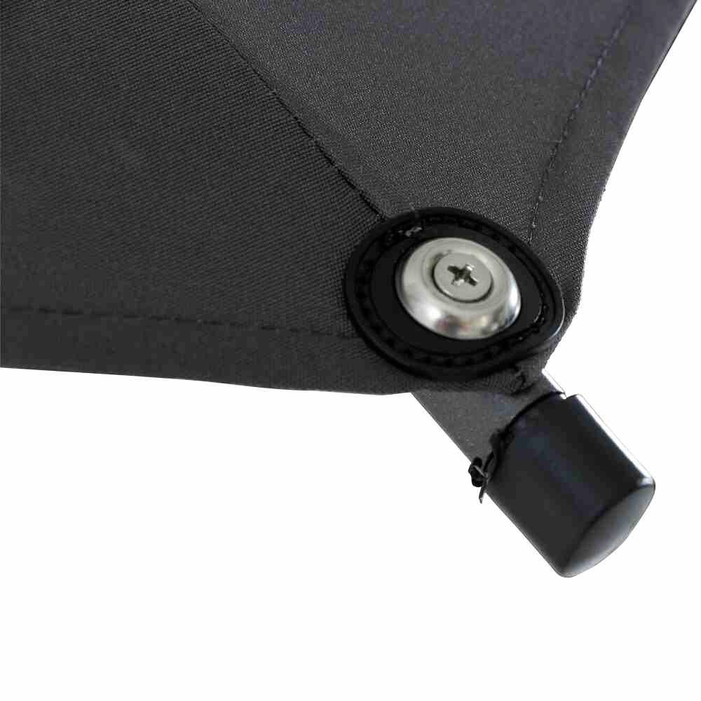 Czarny żagiel przeciwsłoneczny z wytrzymałą metalową pętlą i śrubą mocującą, zamontowany na słupie lub ścianie.