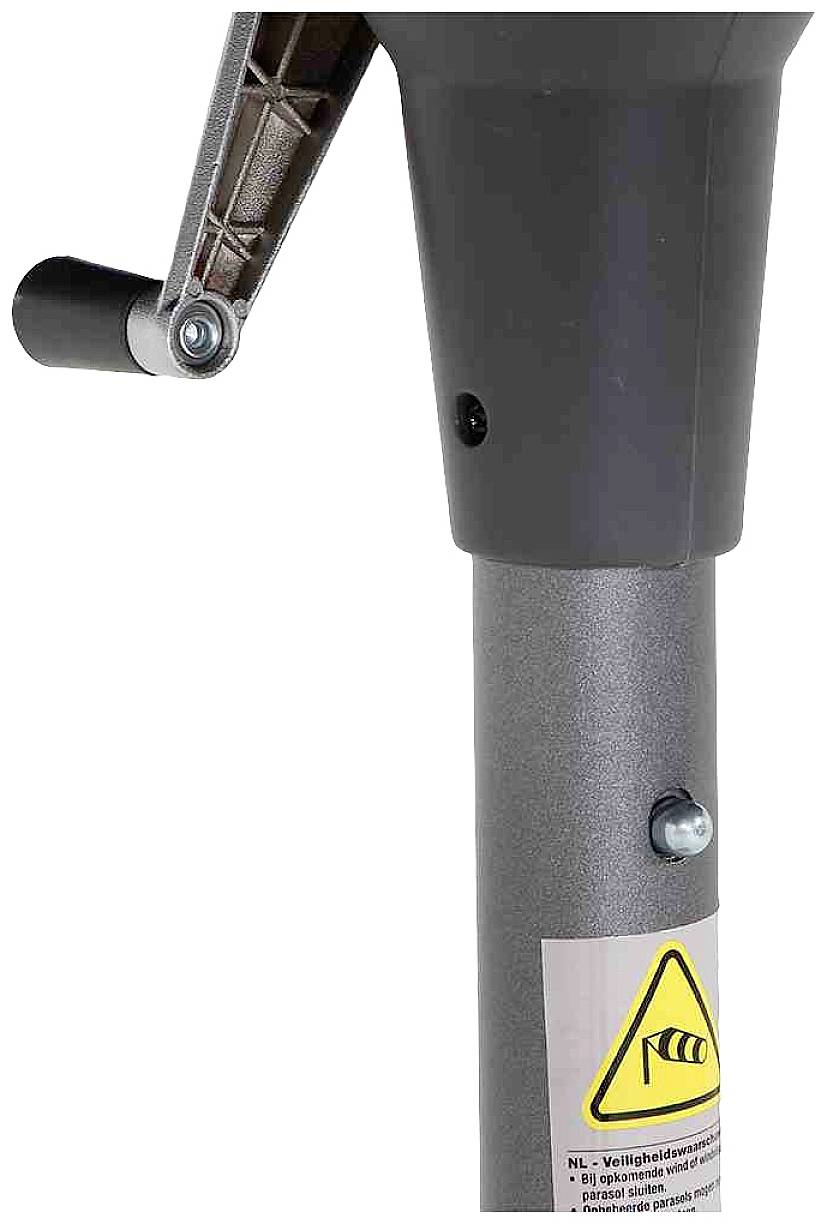 Mechanizm ręcznego korbowania przy szarym metalowym przewodzie z żółtym ostrzeżeniem na dole.