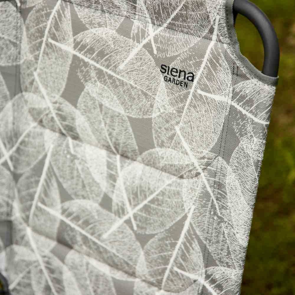 Składany fotel w szarym wzorze od Siena Garden, umieszczony na trawniku na wolnym powietrzu, prezentuje nowoczesny design i komfort do użytku zewnętrznego.
