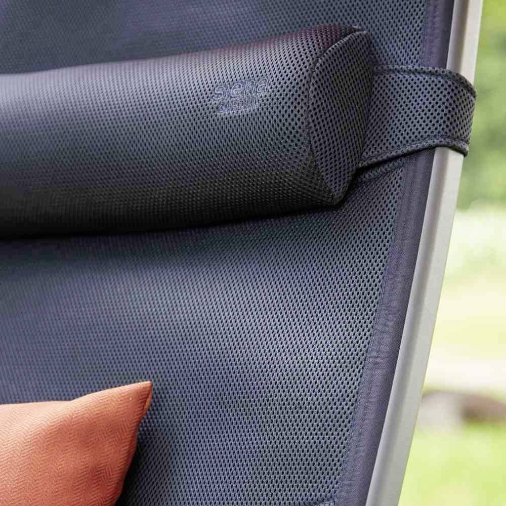 Czarny ergonomiczny fotel biurowy z regulowanym zagłówkiem. Na fotelu leży pomarańczowa poduszka ozdobna.