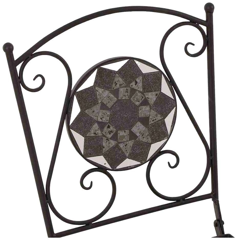 Metalowa rama z okrągłym wzorem mozaikowym pośrodku. Projekt prezentuje geometryczne kształty i symetryczne elementy.