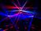 Pokaz świateł z czerwono-niebieskimi promieniami w ciemnej przestrzeni, rozchodzącymi się w różnych kierunkach; tworzy dynamiczną, futurystyczną atmosferę.