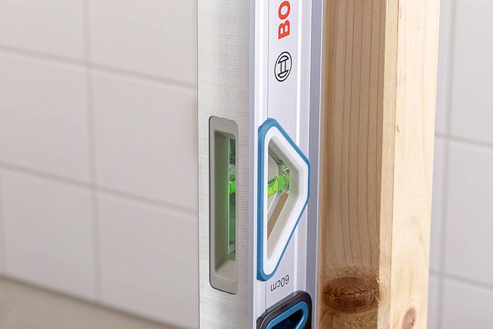 Poziomnica wskazuje prawidłowe, proste ustawienie pionowej krawędzi drewna.